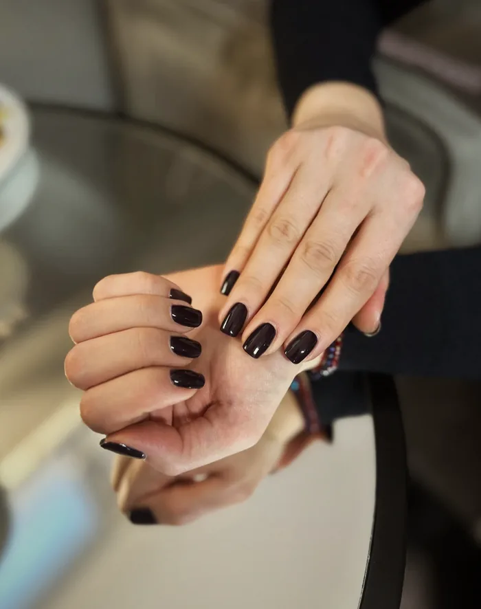 Hände mit dunklem Nagellack