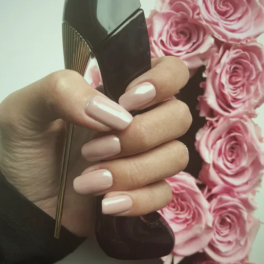 Nude-Maniküre vor rosa Rosen